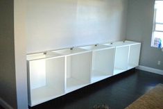 an empty room with white cabinets and shoes on the floor