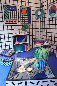 a living room filled with lots of furniture and art work on top of a blue floor