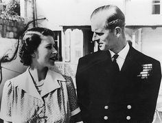 an old black and white photo of a man in uniform standing next to a woman