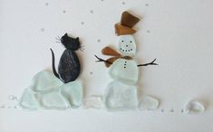 two snowmen and a cat made out of clay