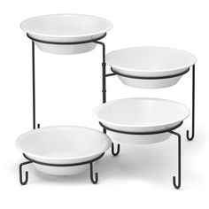 three white plates sitting on top of each other in front of a metal stand with black legs