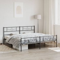 a bed sitting on top of a wooden floor next to a white wall in a bedroom