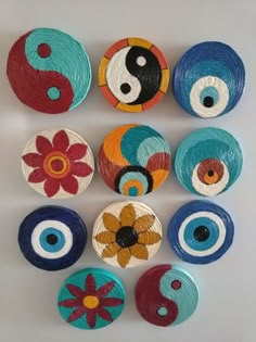 six different types of painted wooden discs with yin - yang symbols on them, all in various colors