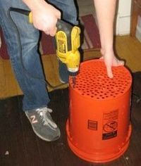 a man is using a drill to fix a fire hydrant on the floor in front of him