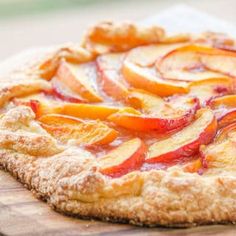 a fresh peach pie on a wooden cutting board