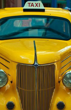 the front end of a yellow taxi cab