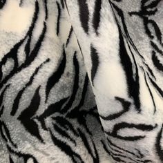 closeup of zebra print fabric in grey and white color scheme, as seen from the neck down