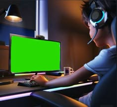 a person wearing headphones and using a computer with a green screen