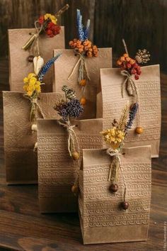 four brown bags with dried flowers tied to them