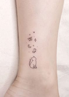 a small tattoo on the ankle of a woman's foot with cats and stars