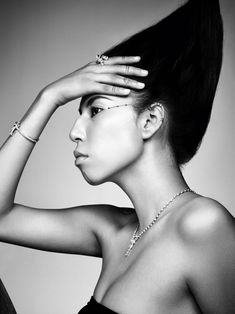 black and white photograph of a woman with her hand on her head, wearing a necklace