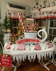 a table that has some candy canes on it and christmas decorations in the background