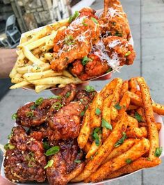 two trays filled with different types of food on top of each other, including french fries and meatballs