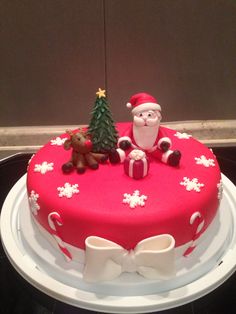 a christmas cake decorated with santa claus and other decorations