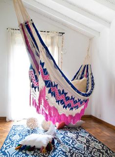 a hammock hanging in the middle of a room with a cat laying on it