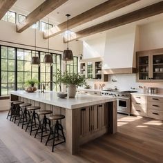 a large kitchen with wooden floors and lots of counter space in front of the windows