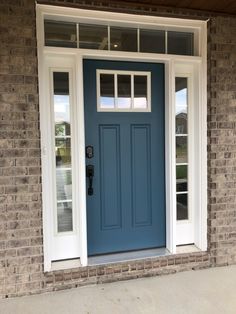 a blue front door with two windows and a phone on the side walk next to it