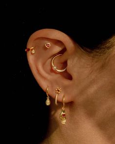 a woman with ear piercings on her left side and an earring in the middle