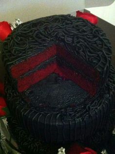 a black and red cake with roses around it