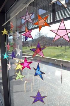 some colorful stars hanging from the side of a window