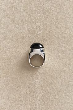 a black and white ring sitting on top of a carpeted floor next to a wall