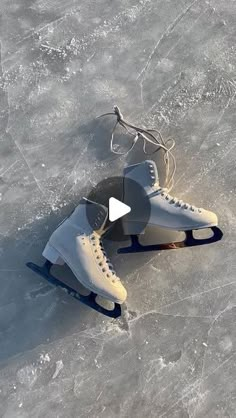 two ice skates sitting on top of an ice covered surface with strings attached to them