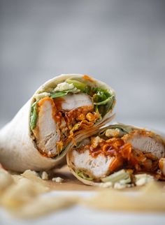 two wraps filled with meat and vegetables on top of a table