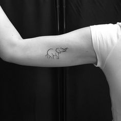 a woman's arm with an elephant tattoo on the left side of her arm