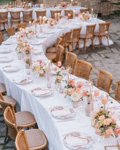 a long table is set with plates and place settings for an elegant wedding reception in the garden