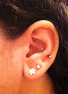 a close up of a person with ear piercings on their ears and behind the ear