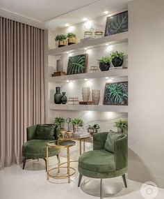 a living room with two green chairs and some plants on the shelves above them in front of a window