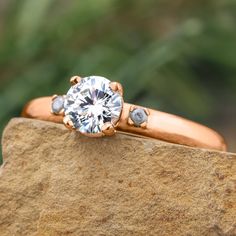 a diamond ring sitting on top of a rock