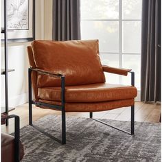 a brown leather chair sitting in front of a window next to a book shelf filled with books