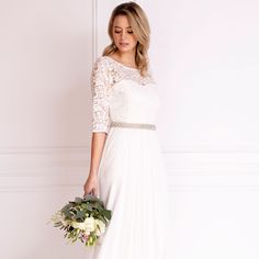 a woman in a white dress holding a bouquet