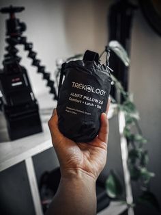 a person holding up a black bag with the words treelogg on it in front of a camera