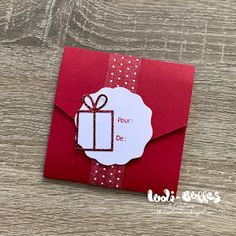 a red envelope with a white tag on it and a bow around the corner that says four de