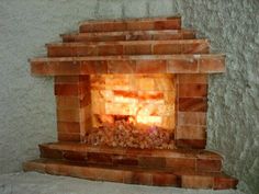 a brick fireplace is lit with the light coming from it's top and side