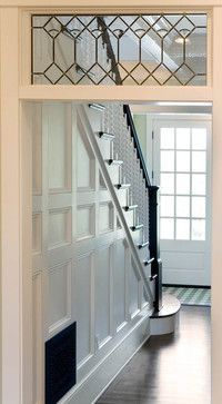 an open door with a stair case in the middle and a window above it on the other side