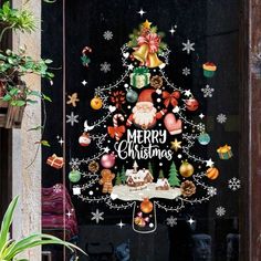 a christmas tree decorated with ornaments and decorations in front of a glass door that says merry christmas