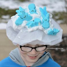 a young boy wearing a paper hat with blue buttons