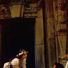 a bride and groom standing in front of an old building with carvings on the walls