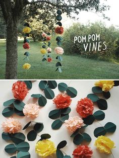 paper flowers and leaves are hanging from the tree in front of a field with trees