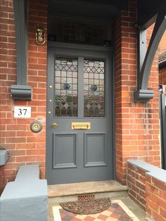 the front door to a brick house with stained glass windows and an entryway mat