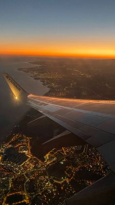 the wing of an airplane flying over a city at night