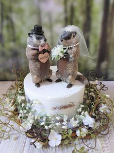 two wedding beaver figurines on top of a cake