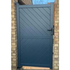 an image of a blue gate in front of a brick wall and door with a glass window