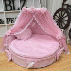 a round bed with pink sheets and pillows