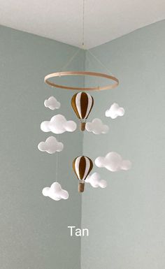 a mobile with hot air balloons hanging from it's sides in the shape of clouds