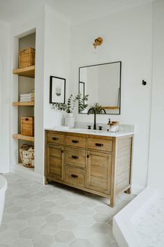 a bathroom with white walls and wooden cabinets