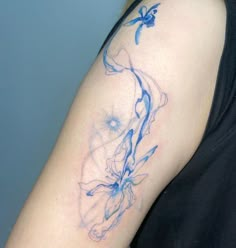 a woman's arm with blue ink on it and a bird flying over her shoulder